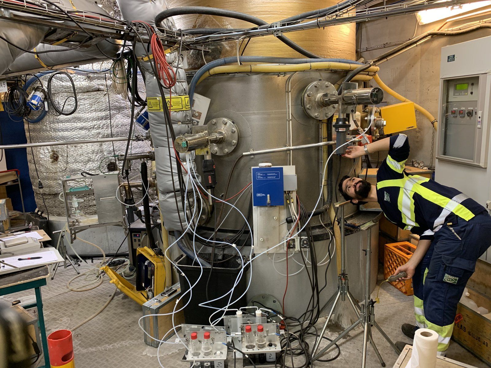 Measurement engineers at sampling equipment inside a boiler house