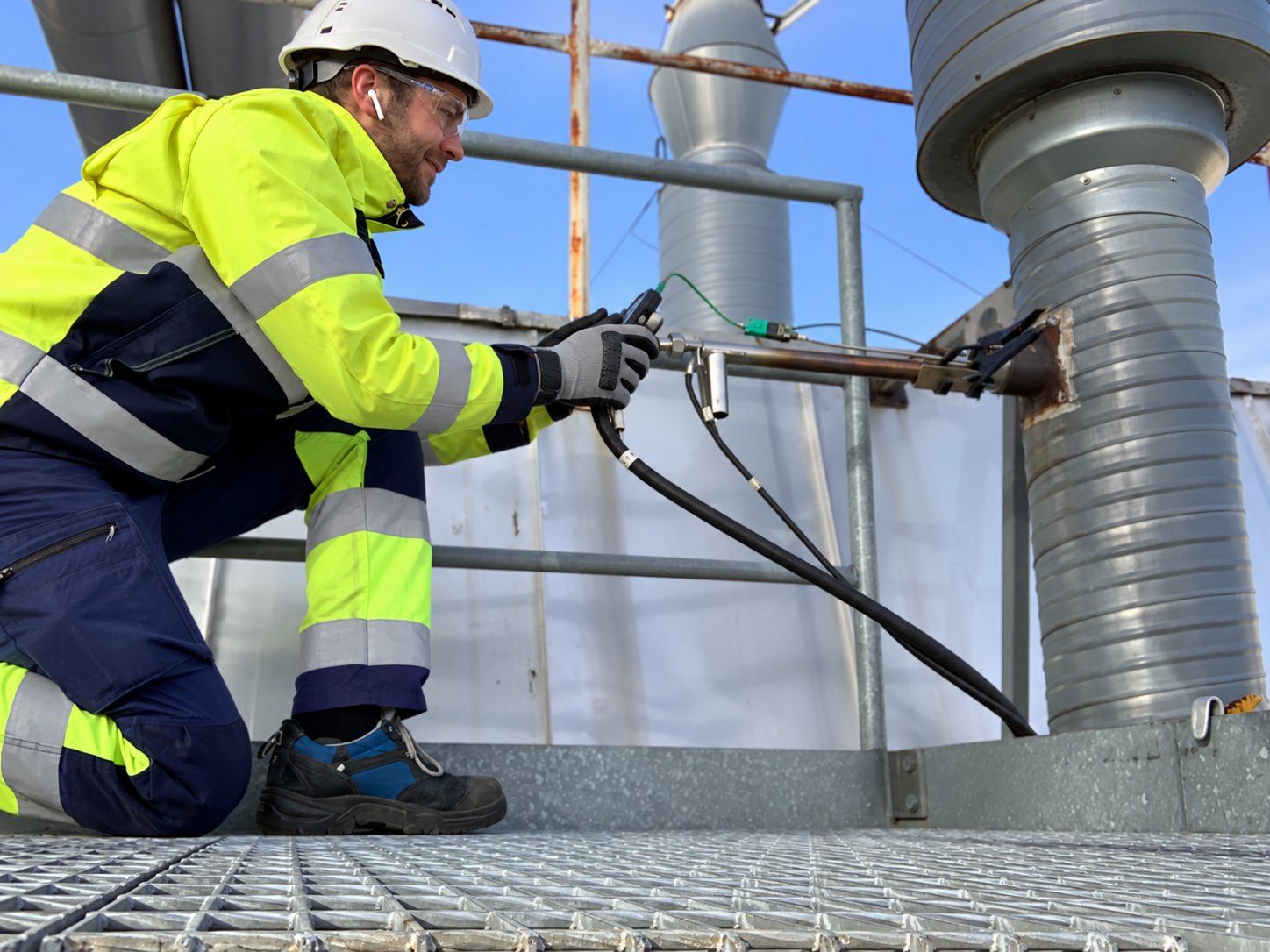 Measurement engineer measuring gas flow with a pitot tube at an outdoor duct