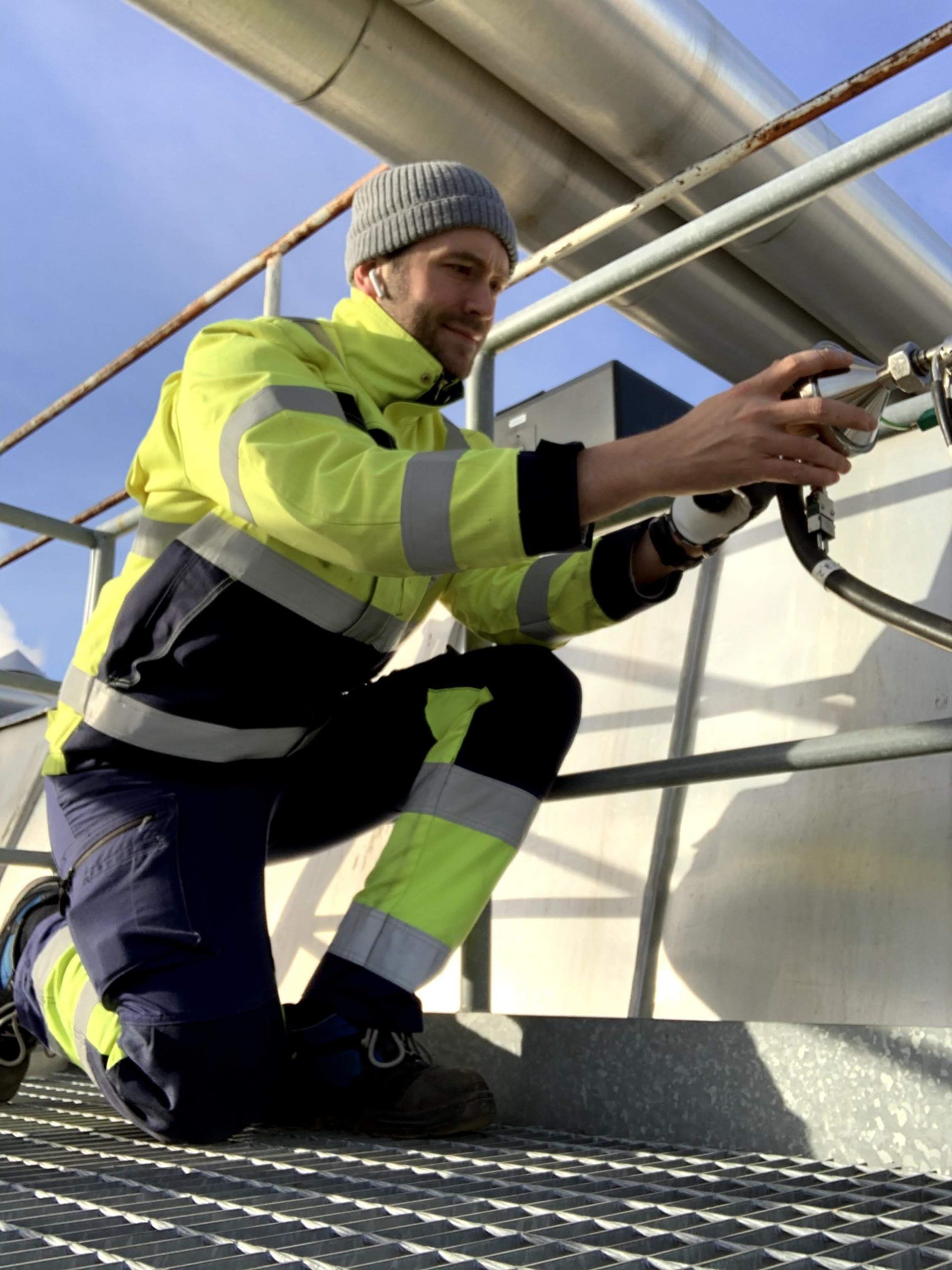 METLAB measurement engineer connecting a probe at a sampling port on an outdoor platform