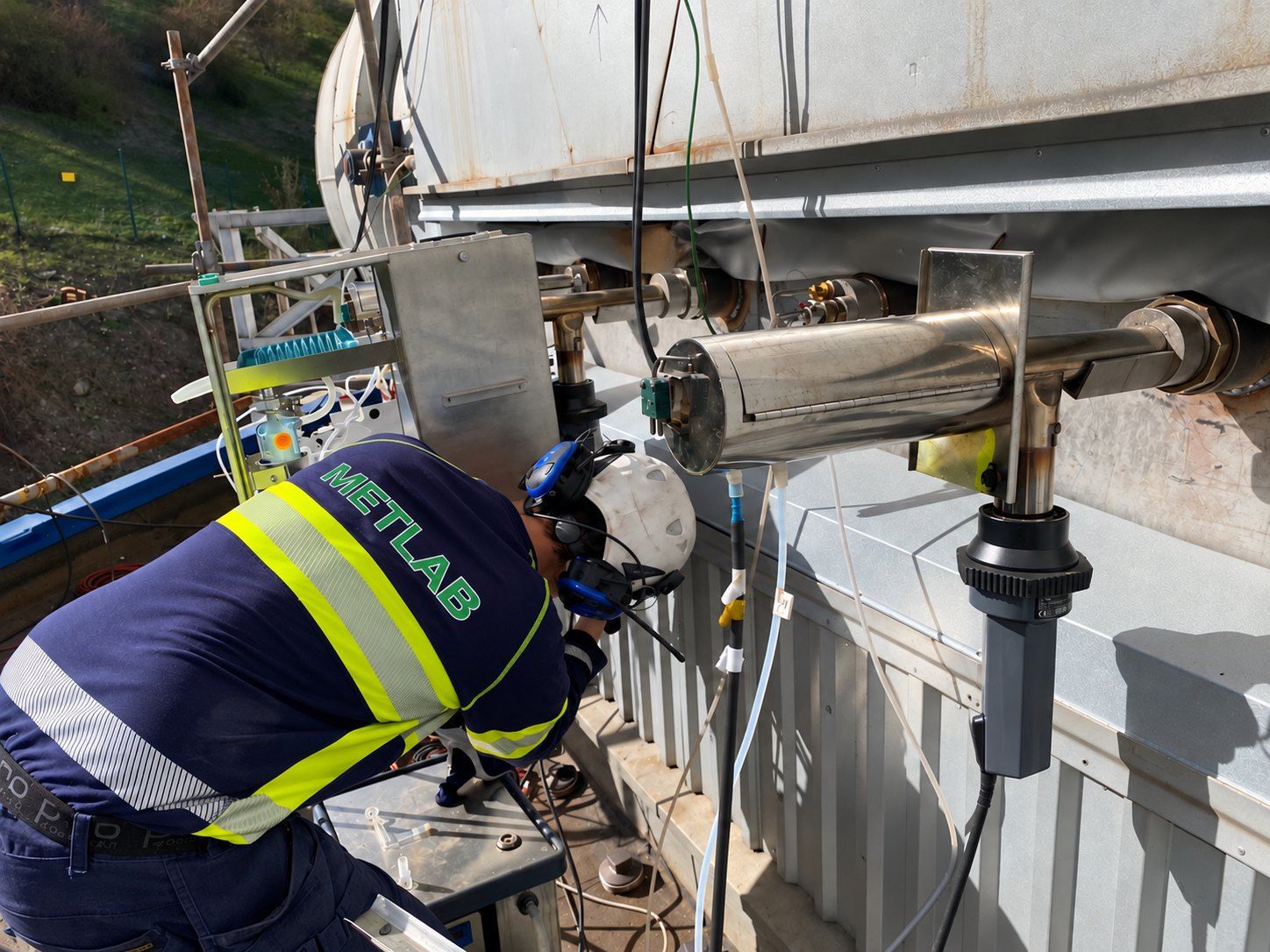 Measurement engineer at a sampling probe mounted in the sampling port of a flue gas duct