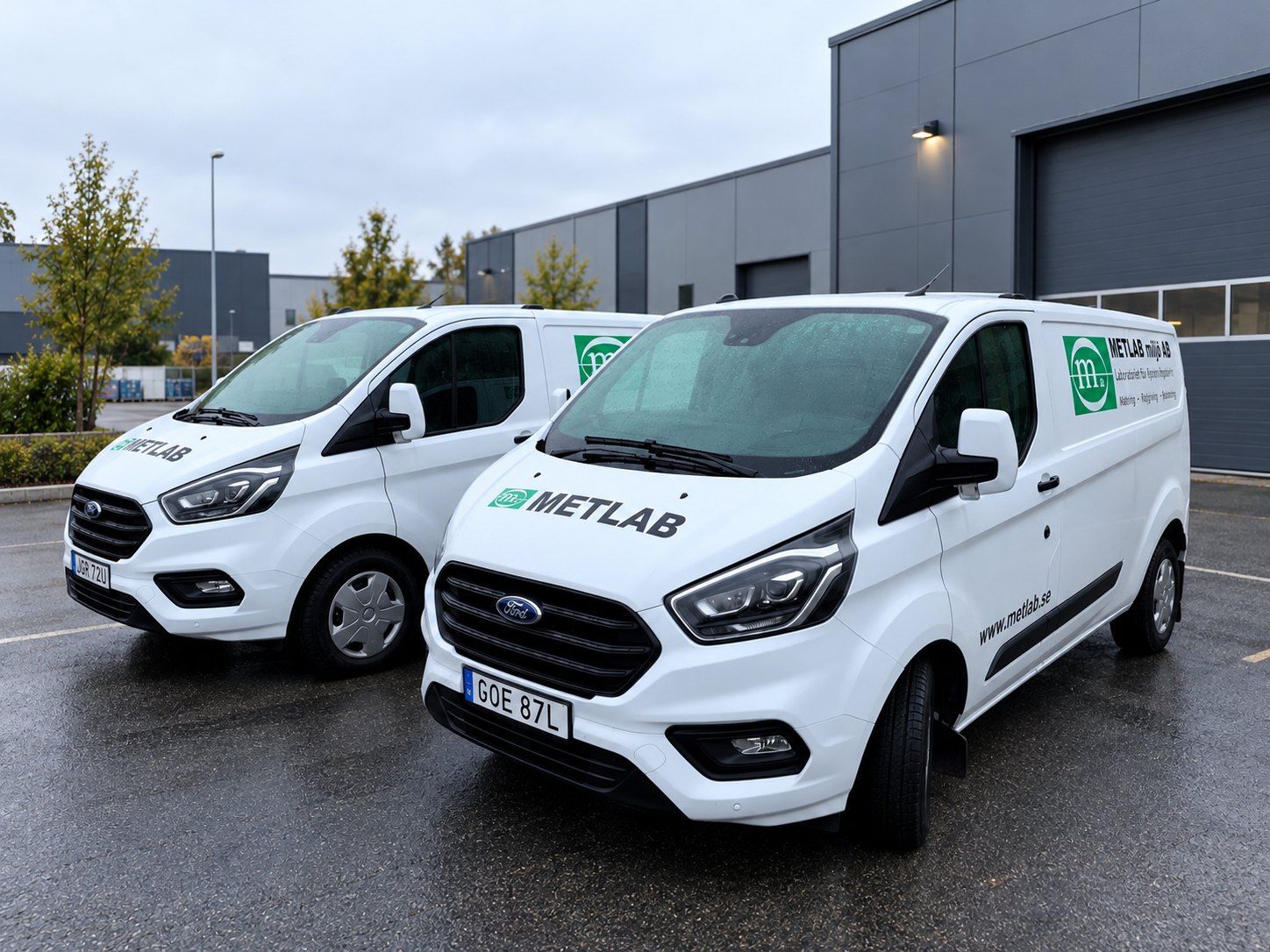 Two METLAB cars parked in front of a building